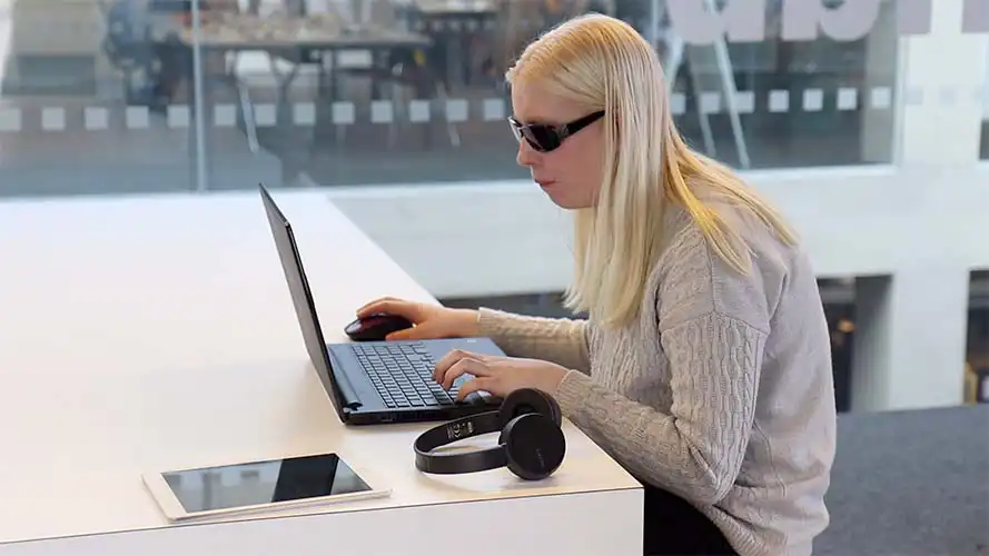 Hands typing on a laptop at a school desk